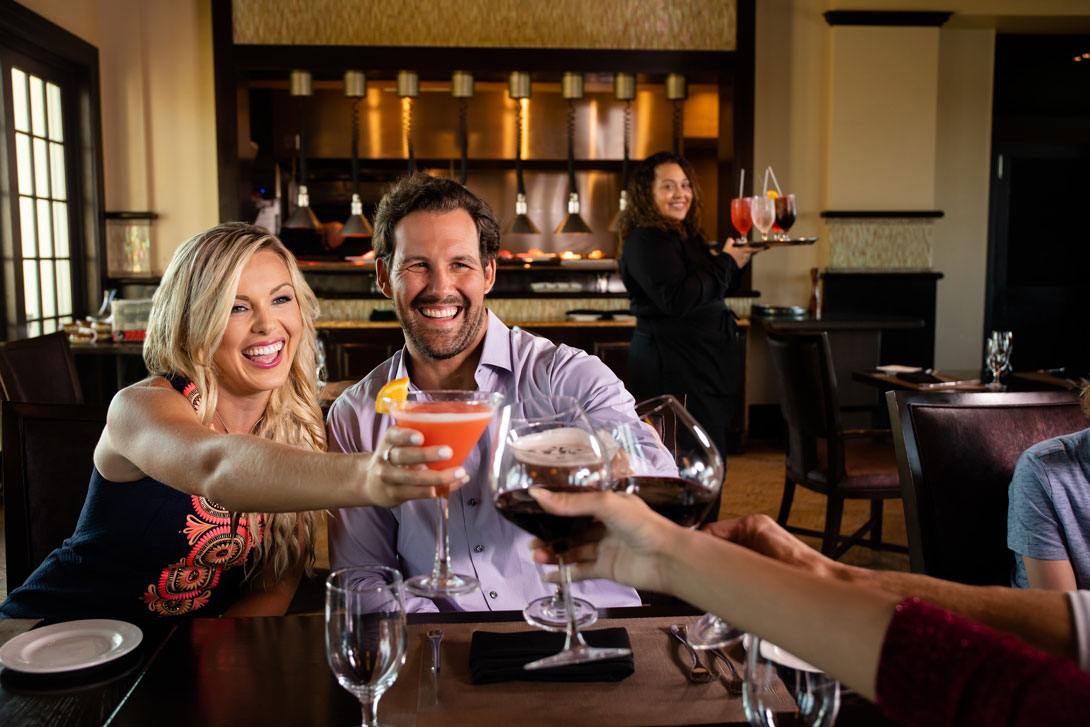 2 couples toast with their drink glasses at Traditions restaurant.