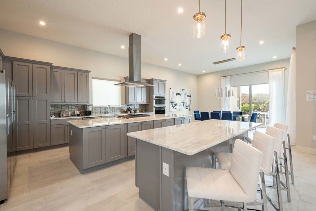 Large kitchen with dual islands and barstool seating in an elegant 8-bedroom Bear’s Den Resort Orlando residence.