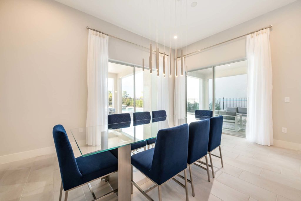Dining room with outdoor lanai access in an elegant 8-bedroom Bear’s Den Resort Orlando residence.