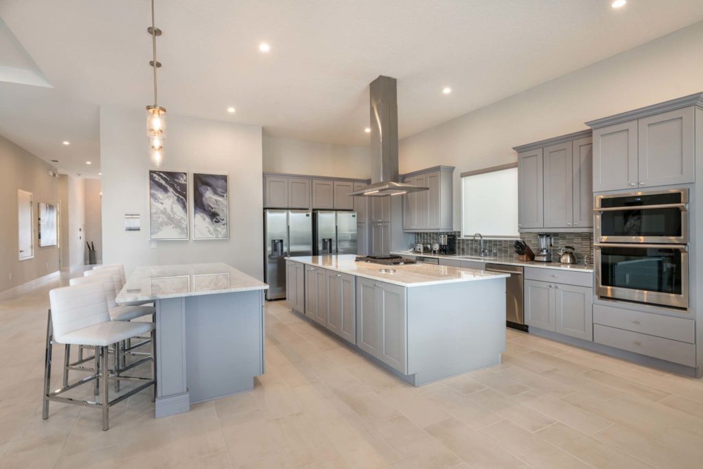 Spacious kitchen with dual islands and barstool seating in an elegant 8-bedroom Bear’s Den Resort Orlando residence.
