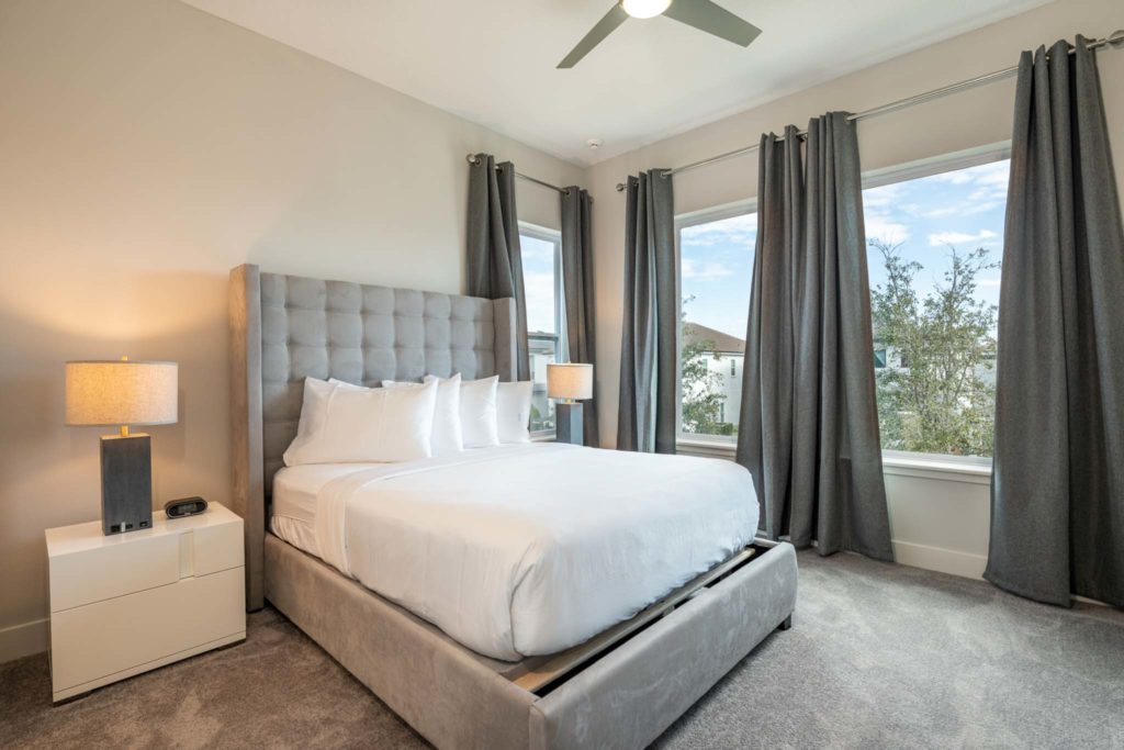 Large king bed and windows in an elegant 8-bedroom Bear’s Den Resort Orlando residence.