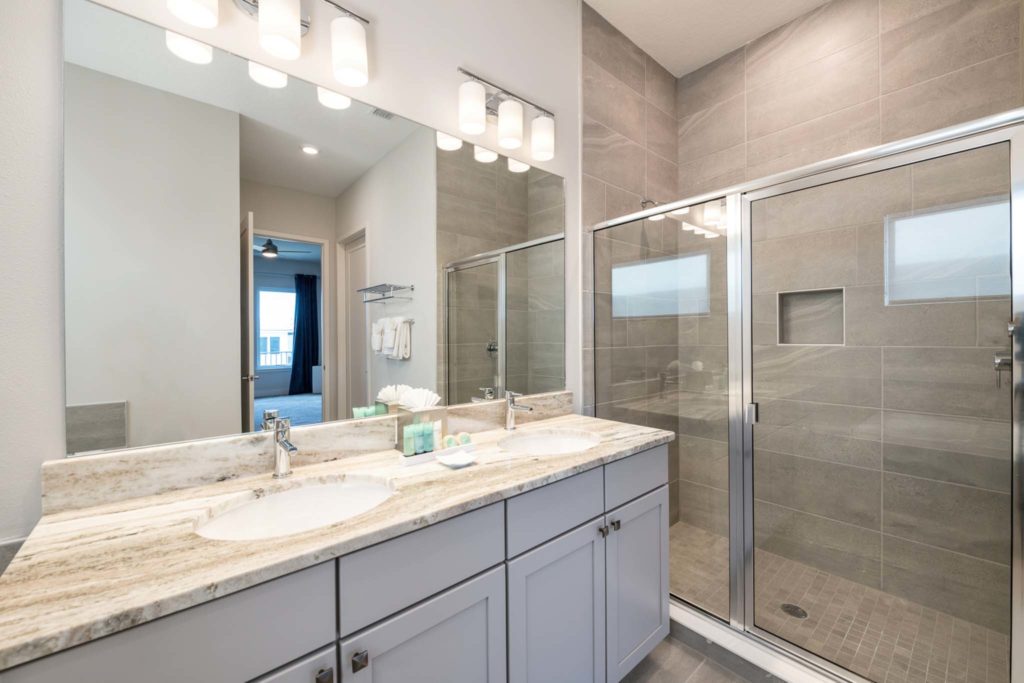 Standing shower, sink, and mirror in an elegant 8-bedroom Bear’s Den Resort Orlando residence.