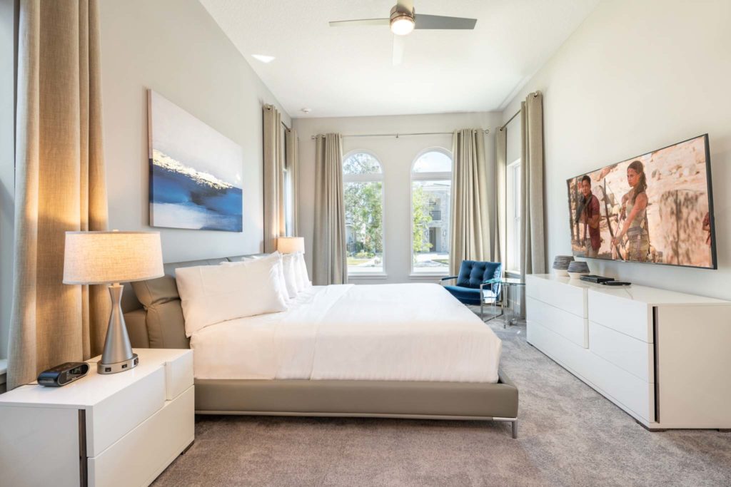 Large king bed and wall-mounted TV at an elegant 8-bedroom Bear’s Den Resort Orlando residence.