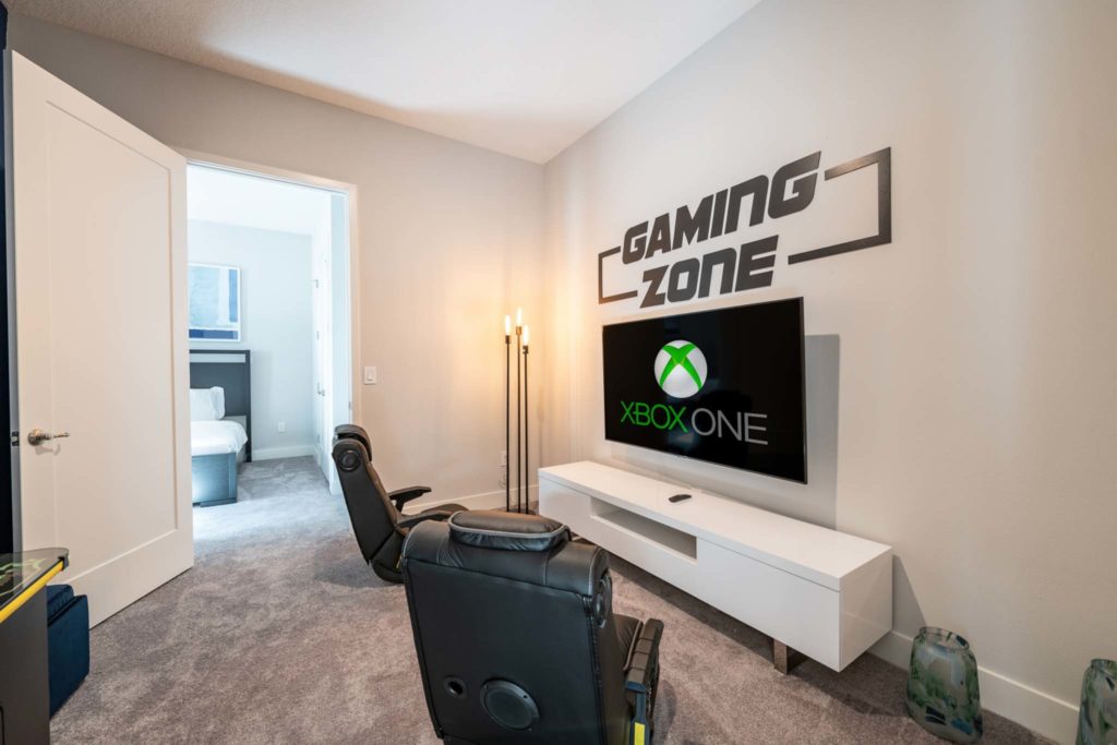 Spacious game room with specialty gaming chairs and Xbox One console in an elegant 8-bedroom Bear’s Den Resort Orlando residence.