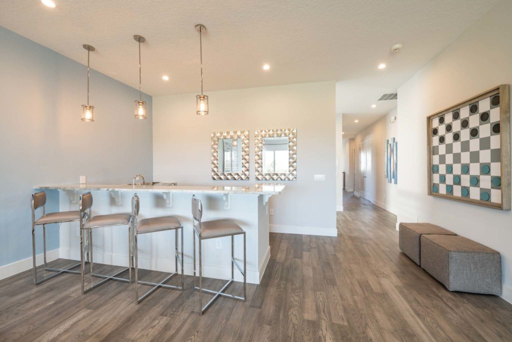 Loft with barstool seating and framed checkerboard wall art in an elegant 8-bedroom Bear’s Den Resort Orlando residence.