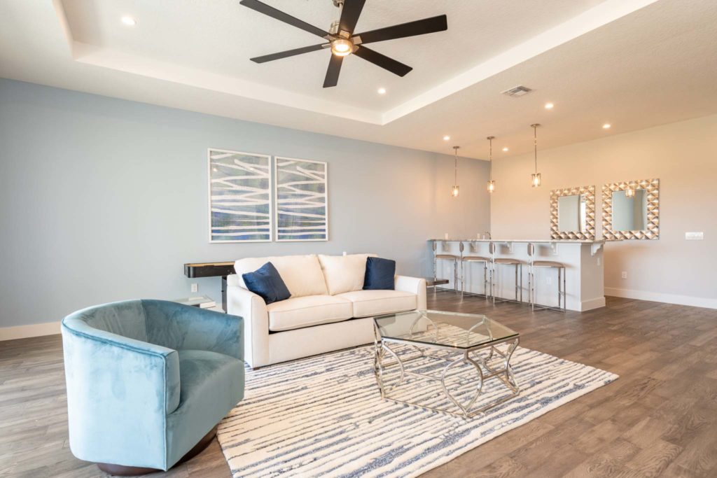 Spacious loft with bar, couch, and shuffleboard table in an elegant 8-bedroom Bear’s Den Resort Orlando residence.