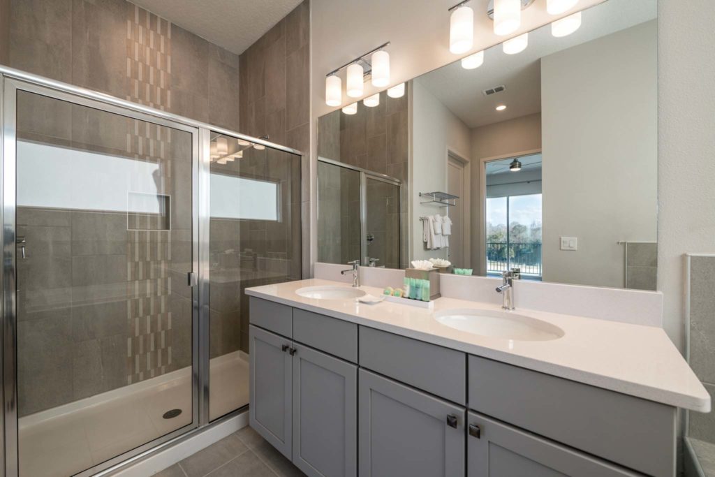 Standing shower and double sink with mirror in an elegant 8-bedroom Bear’s Den Resort Orlando residence.
