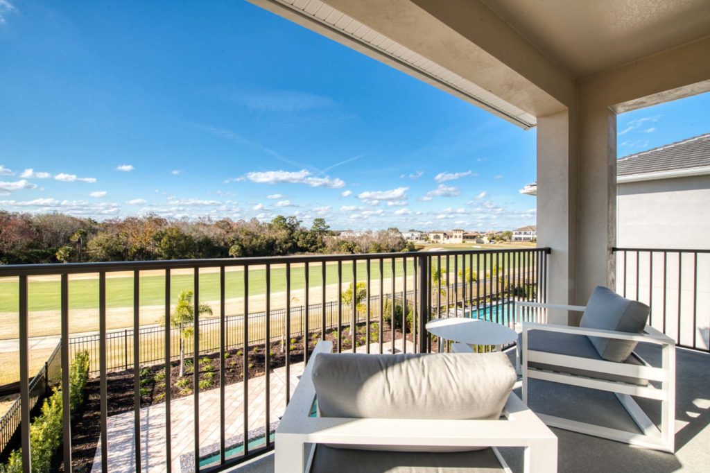 Outdoor covered balcony with golf course view at an elegant 8-bedroom Bear’s Den Resort Orlando residence.