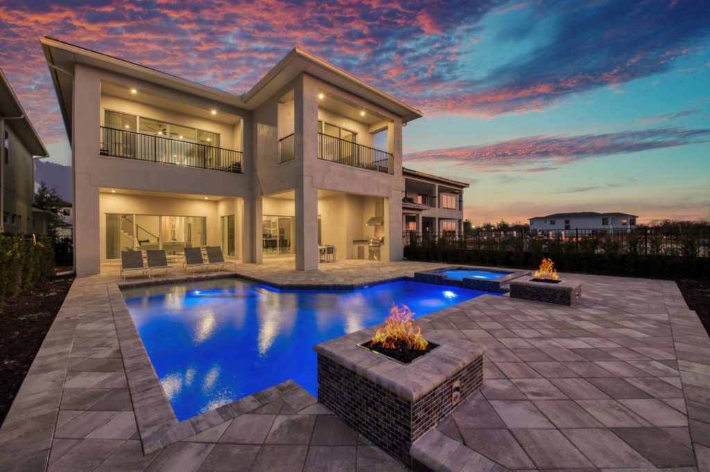Private pool and fire pits at an elegant 8-bedroom Bear’s Den Resort Orlando residence at sunset.