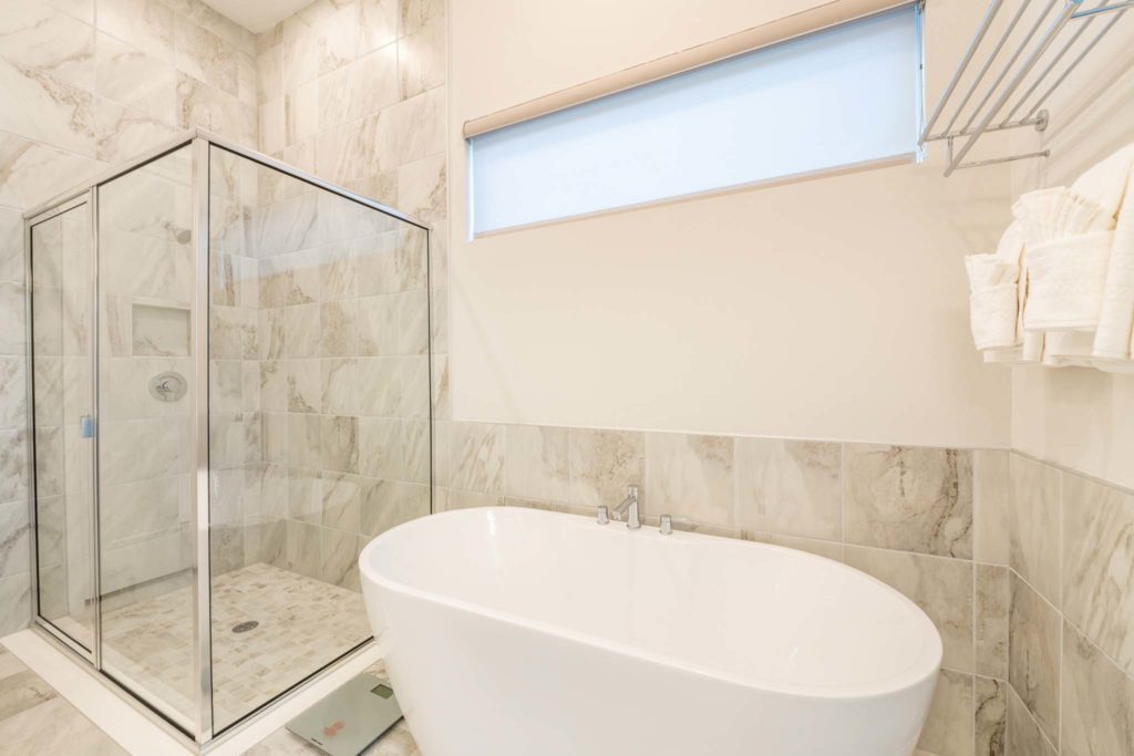 Large bathtub and separate shower in an elegant 8-bedroom Bear’s Den Resort Orlando residence.