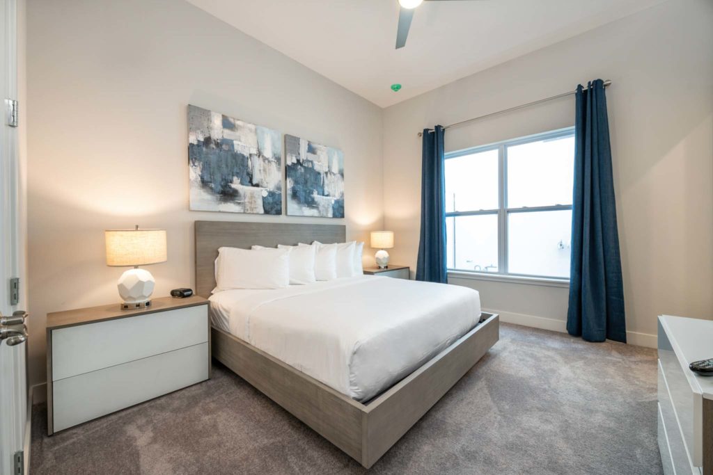 Spacious bedroom with large king bed in an elegant 8-bedroom Bear’s Den Resort Orlando residence.