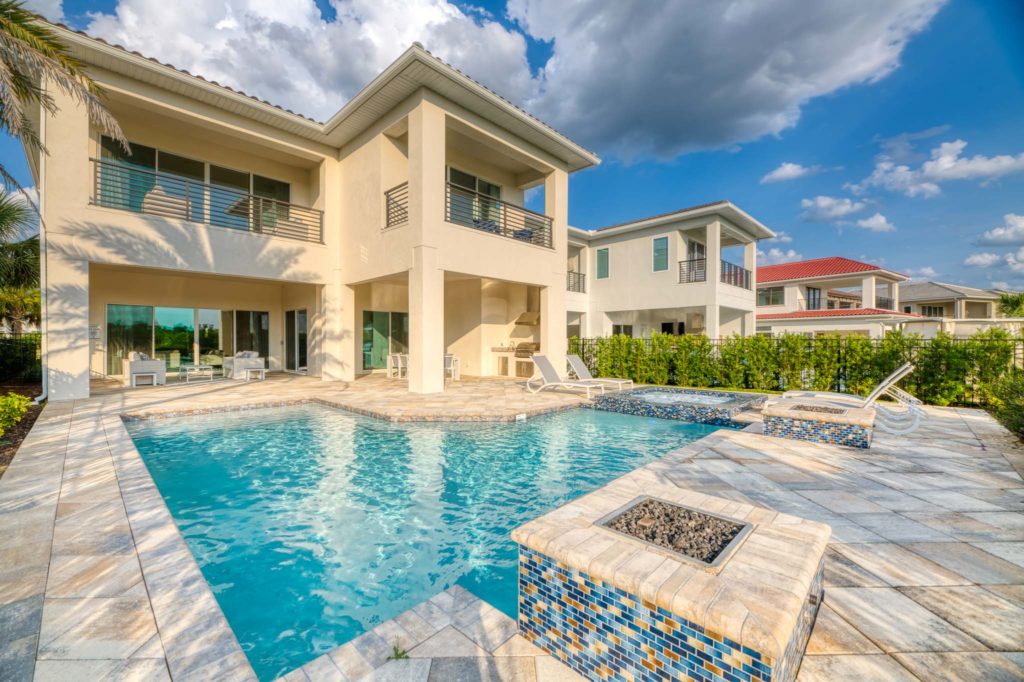 Private backyard of an 8-bedroom resort residence with covered balconies, summer kitchen, pool, hot tub, and fire pits.