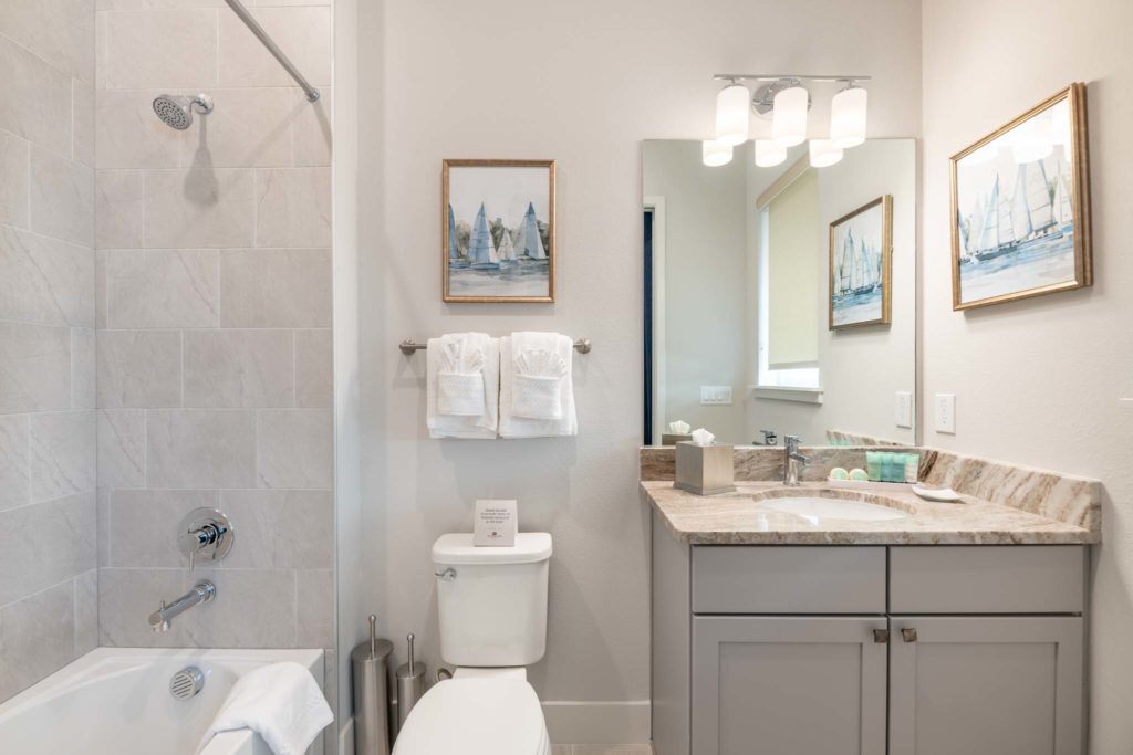 Bathroom with sink, mirror, toilet, and alcove bathtub with shower.