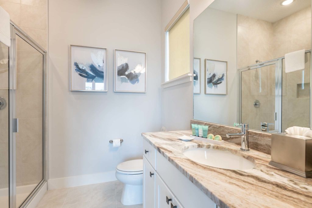 Bathroom with sink, large mirror, toilet, and standing shower stall.