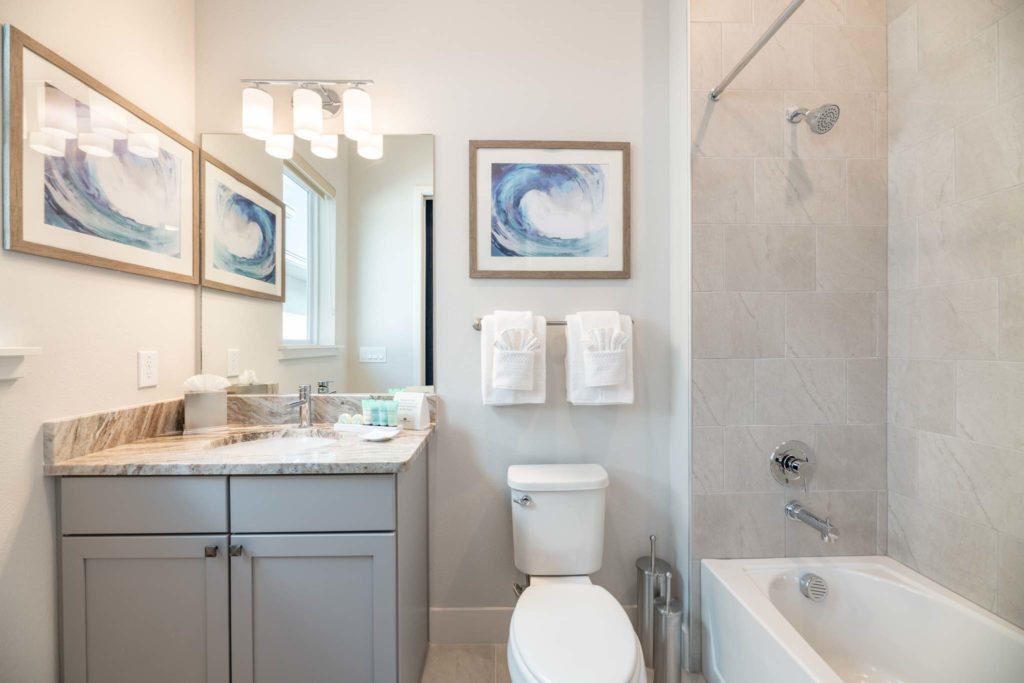 Bathroom with sink, mirror, toilet, and alcove bathtub with shower.