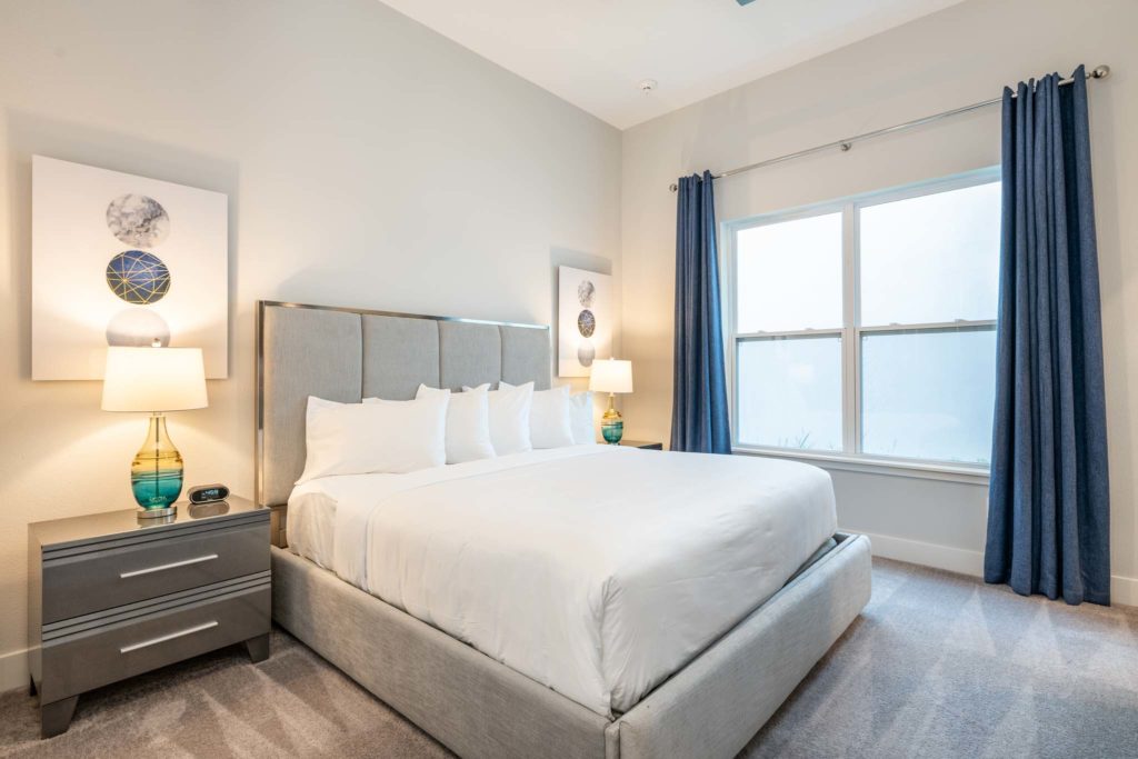 Spacious bedroom with large king bed, plush headboard, and large double window.