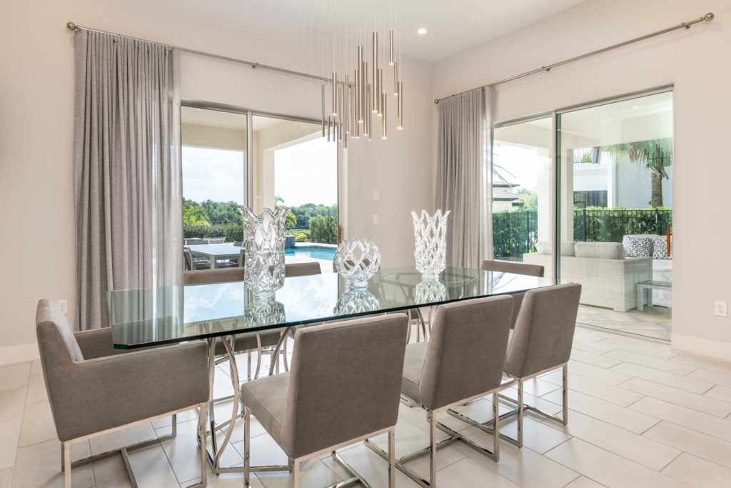 Modern dining room with sliding door access to backyard pool and covered summer kitchen area.