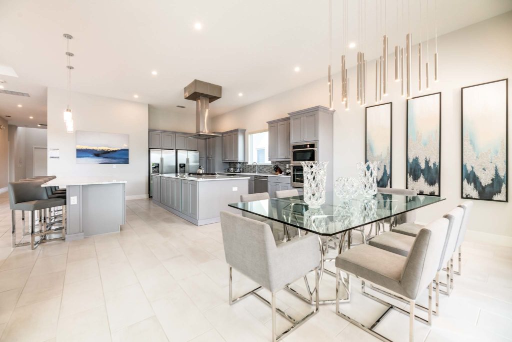 Expansive dining room and kitchen with modern glass dining room table and two kitchen islands for seating.