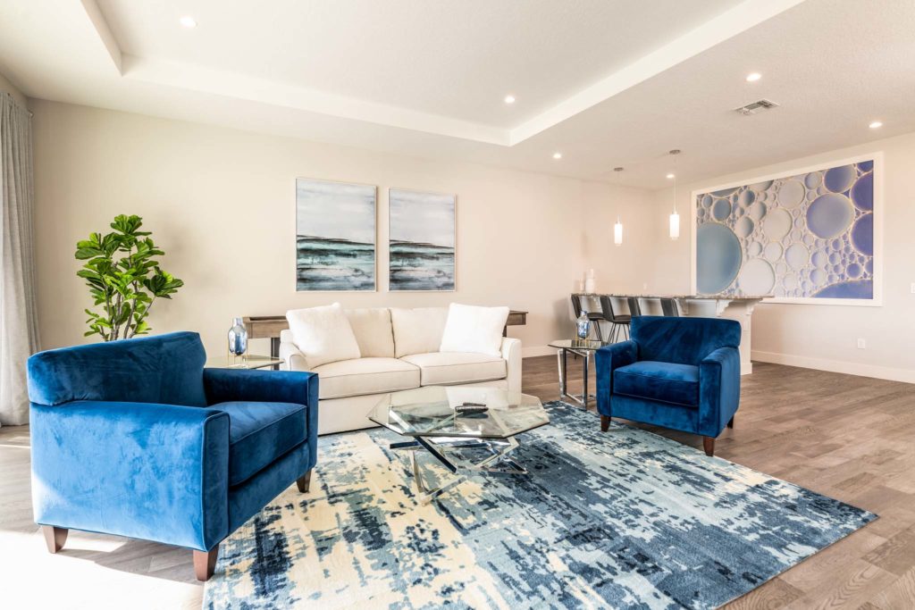 Upper loft with dry bar, plush armchairs, and sofa.