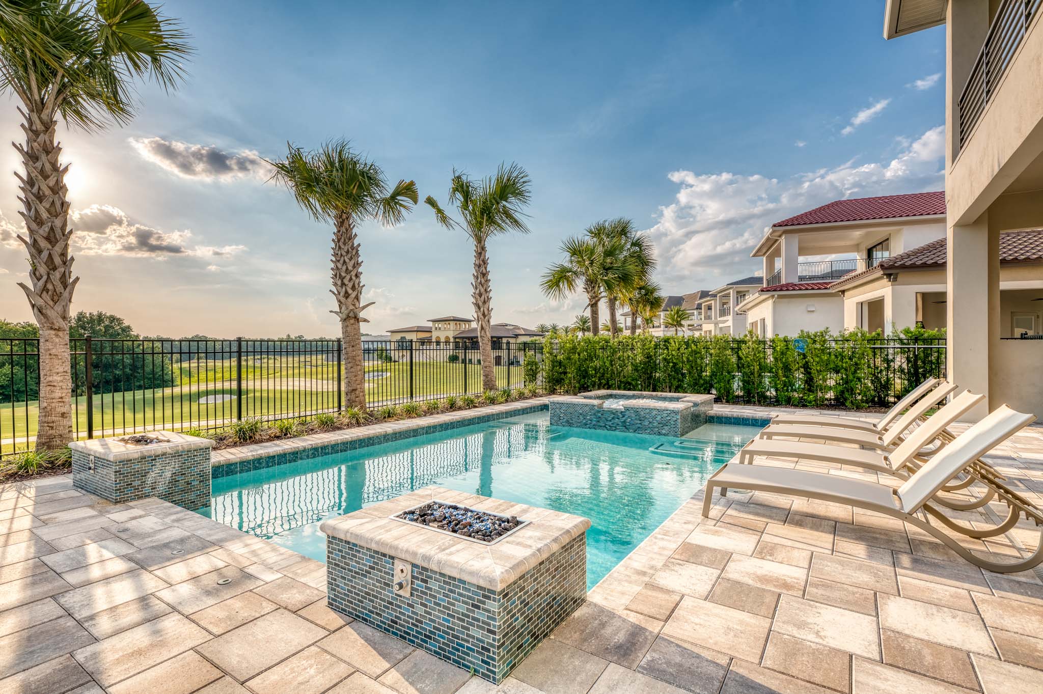 Private backyard patio with pool, fire pits, and golf course view.