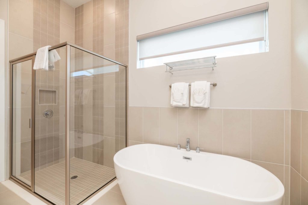Freestanding bathtub and separate glass-door standing shower.