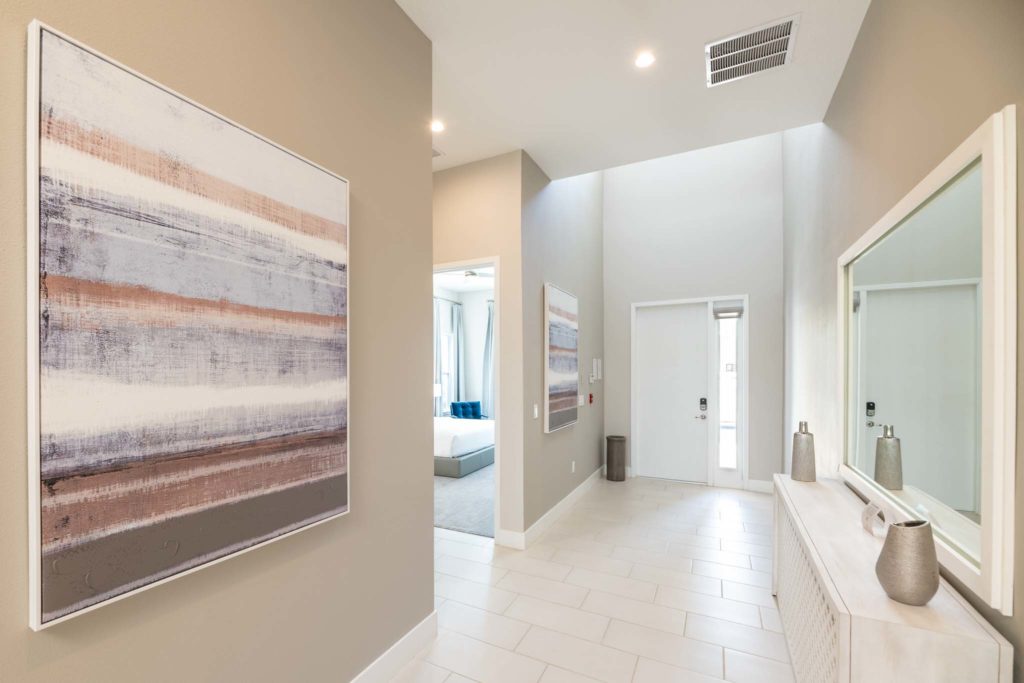 Entrance foyer with decorative wall art, long dresser, and mirror.