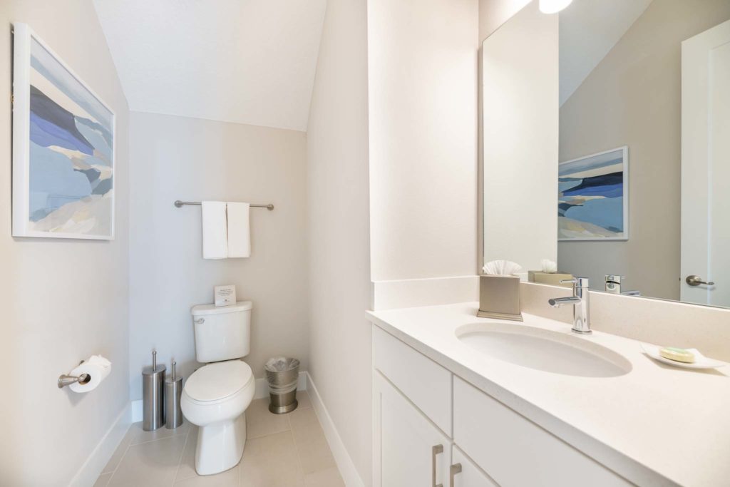 Half bathroom with sink, mirror, and toilet.