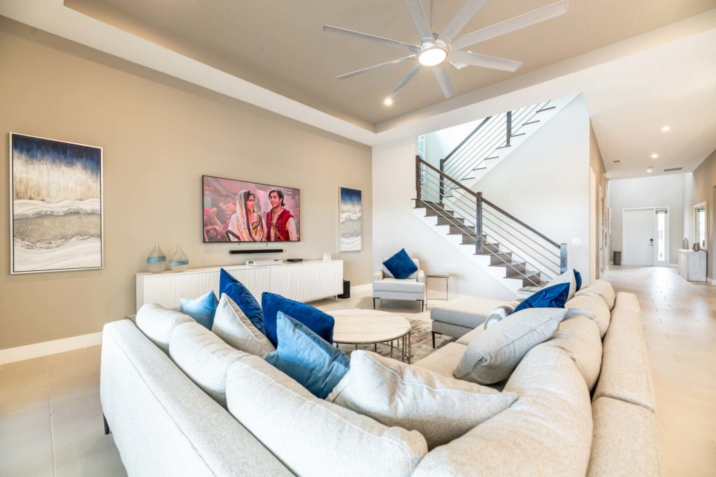 Spacious living room with sectional sofa, large ceiling fan, and wall-mounted TV.
