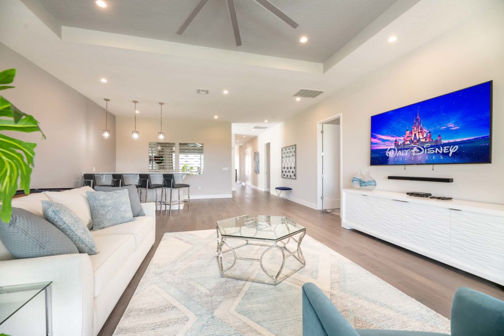 Spacious loft with dry bar, sofa, and wall-mounted TV.