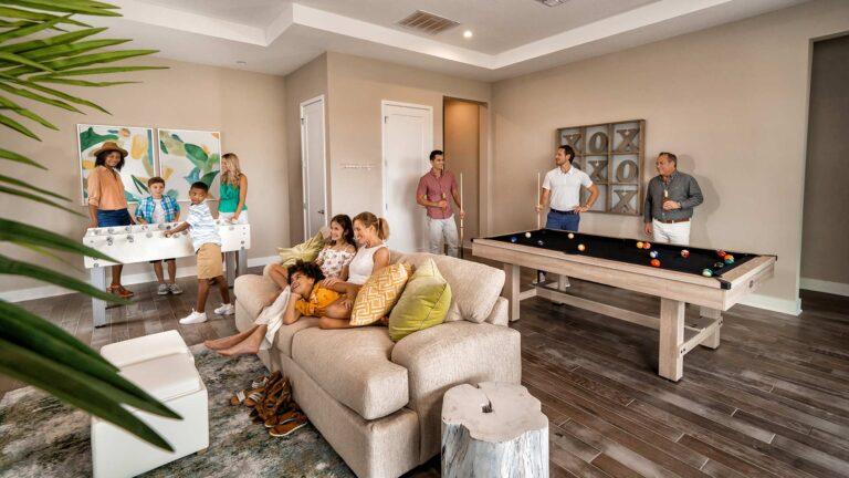 Multiple families playing and relaxing in the game room of their Bear's Den Resort residence.