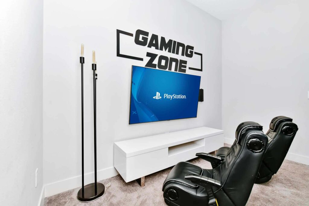 Video game zone with gaming chairs and large flat-screen tv at an elegant 8-bedroom Bear’s Den Resort Orlando residence