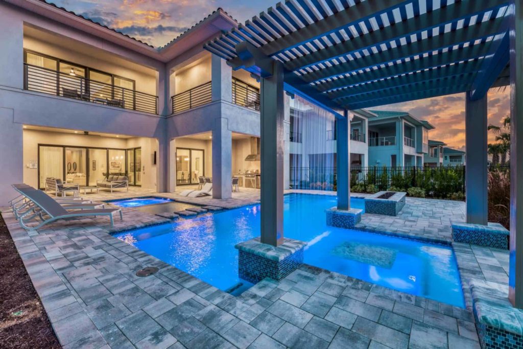 Private pool with waterfall trellis at an 8-bedroom Bear’s Den home at twilight.