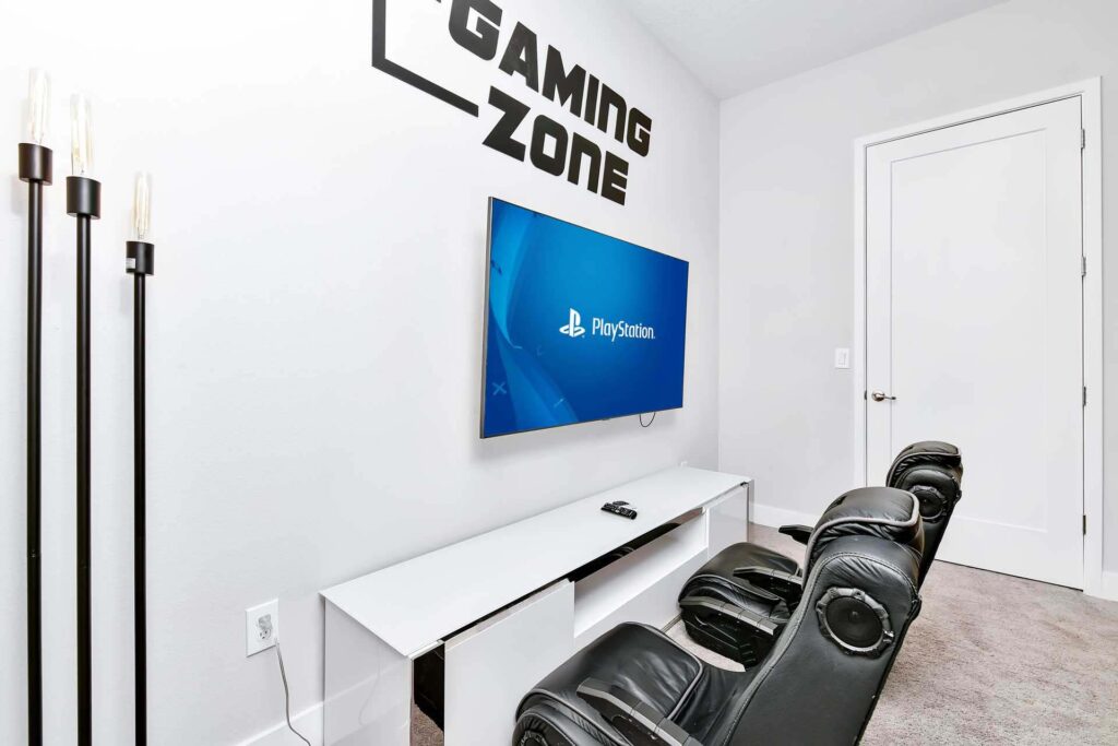 Video game area with gaming chairs and a large flat-screen tv at a superb 8-bedroom Bear’s Den Resort Orlando residence