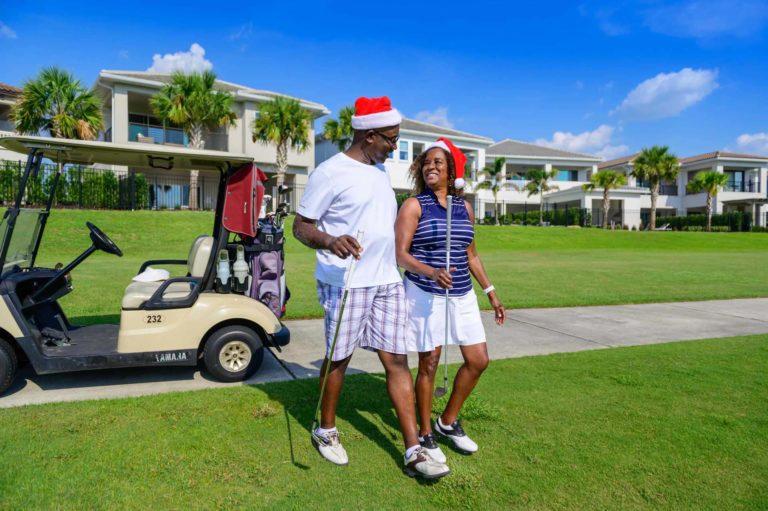 Couple about to play a round of golf while wearing Santa hats at the Bear's Den Resort Orlando