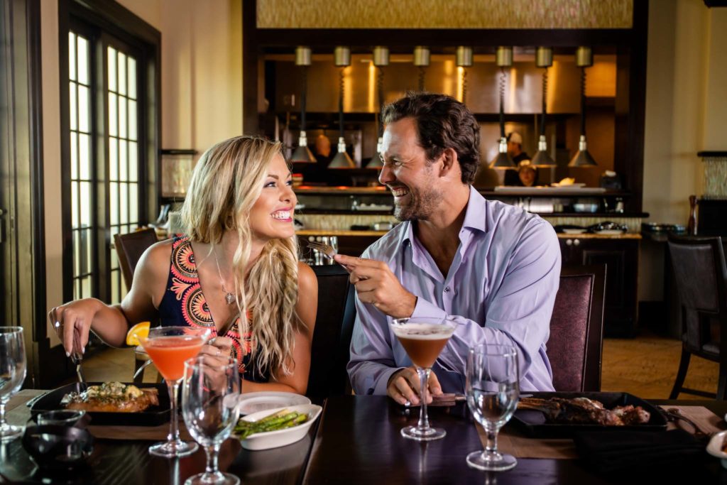 Couple shares food with each other at Traditions restaurant.