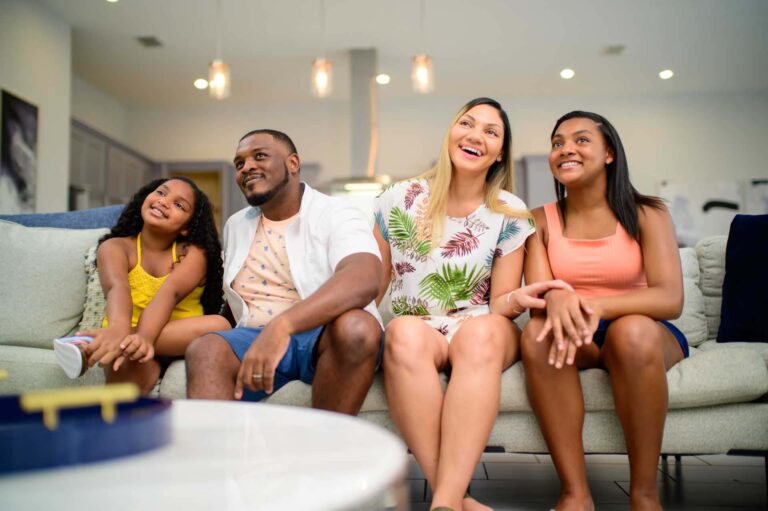 Family relaxing on the couch in their Bear's Den Resort home living room