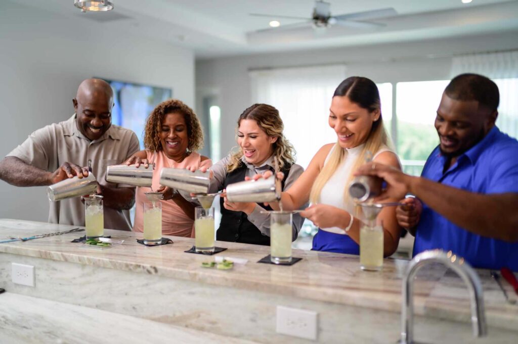 Group mixing cocktails in their private Bear's Den Resort home kitchen for a bartender experience.