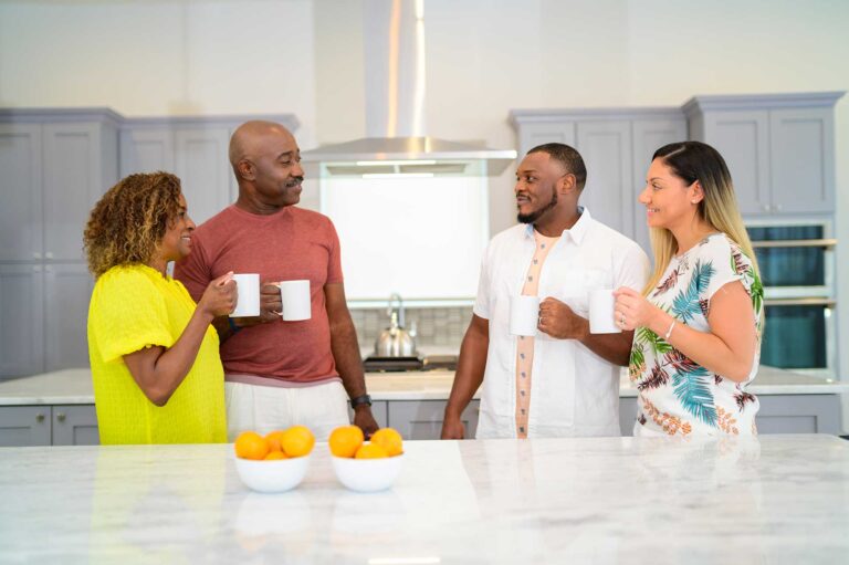 Two couples enjoying their morning coffee in their Bear's Den Resort home kitchen