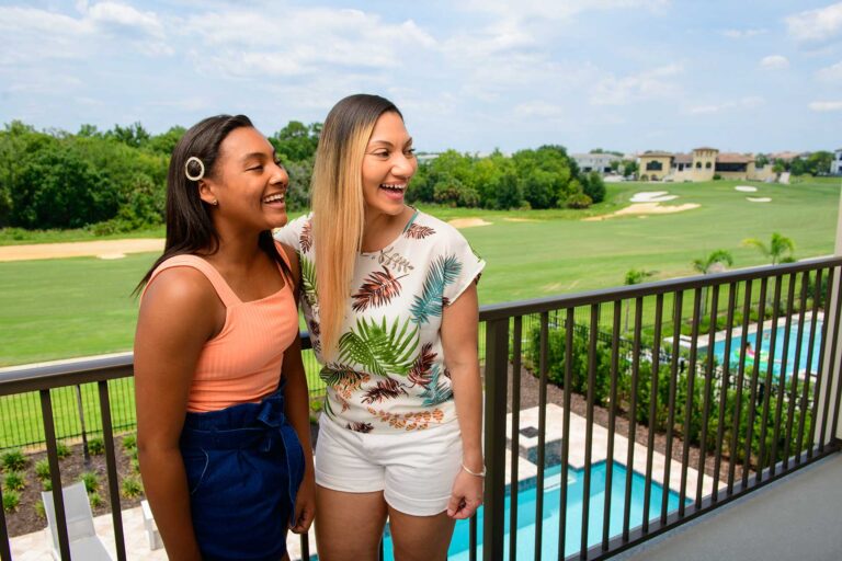 Mother and daughter laughing on their Bear's Den Resort home balcony