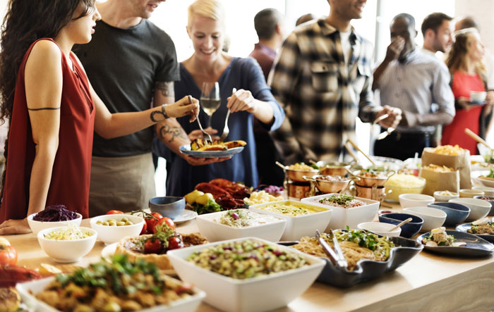 Guests sample food at an indoor catered event.