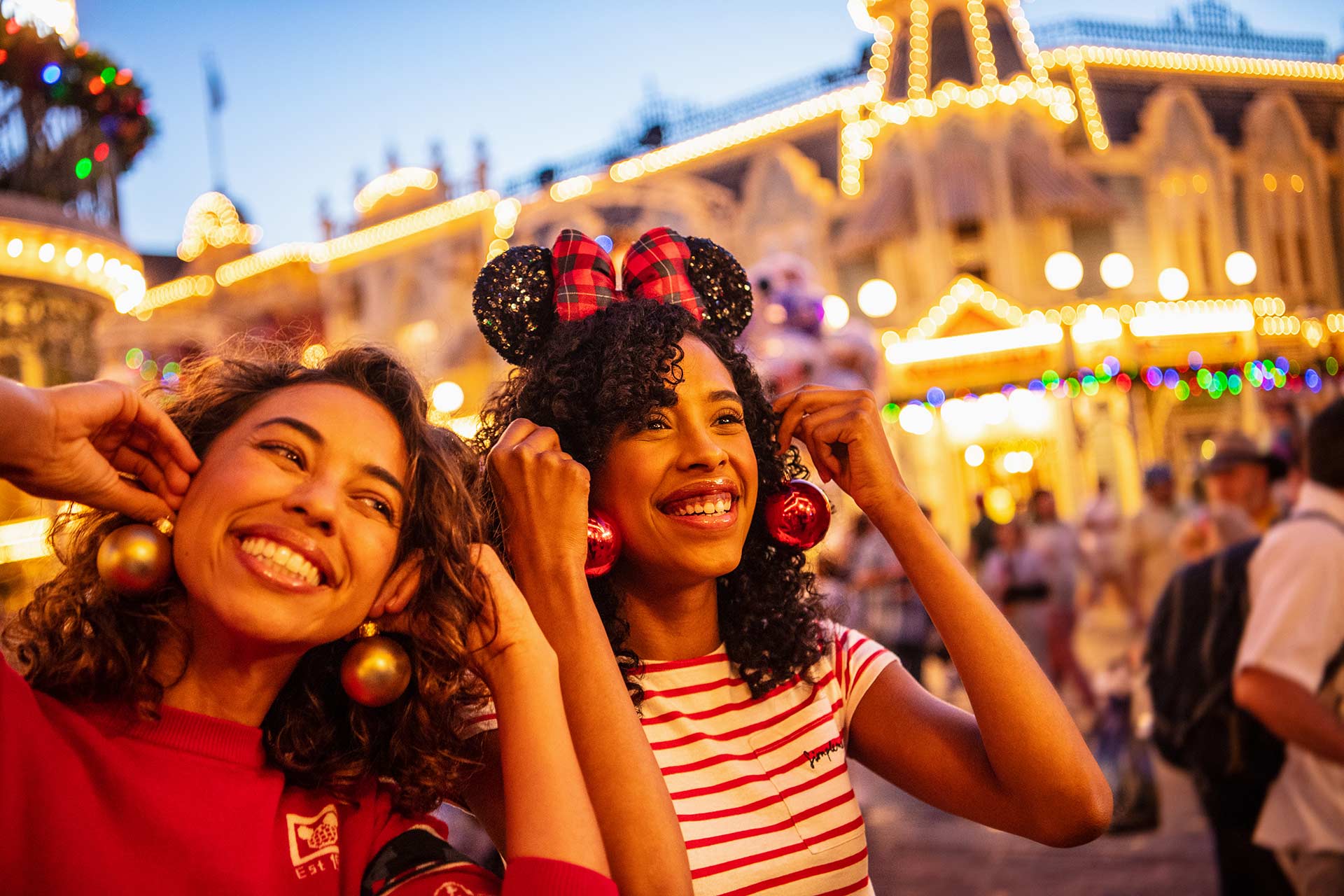 Woman posing with Christmas ornaments as earrings on Main Street USA at the Magic Kingdom