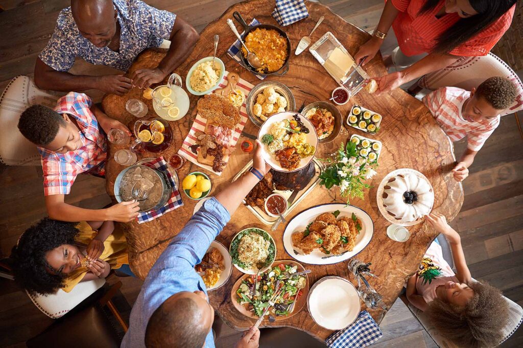 Overhead view of a family enjoying a table full of souther comfort food at Art Smith's Homecomin' at Disney Springs