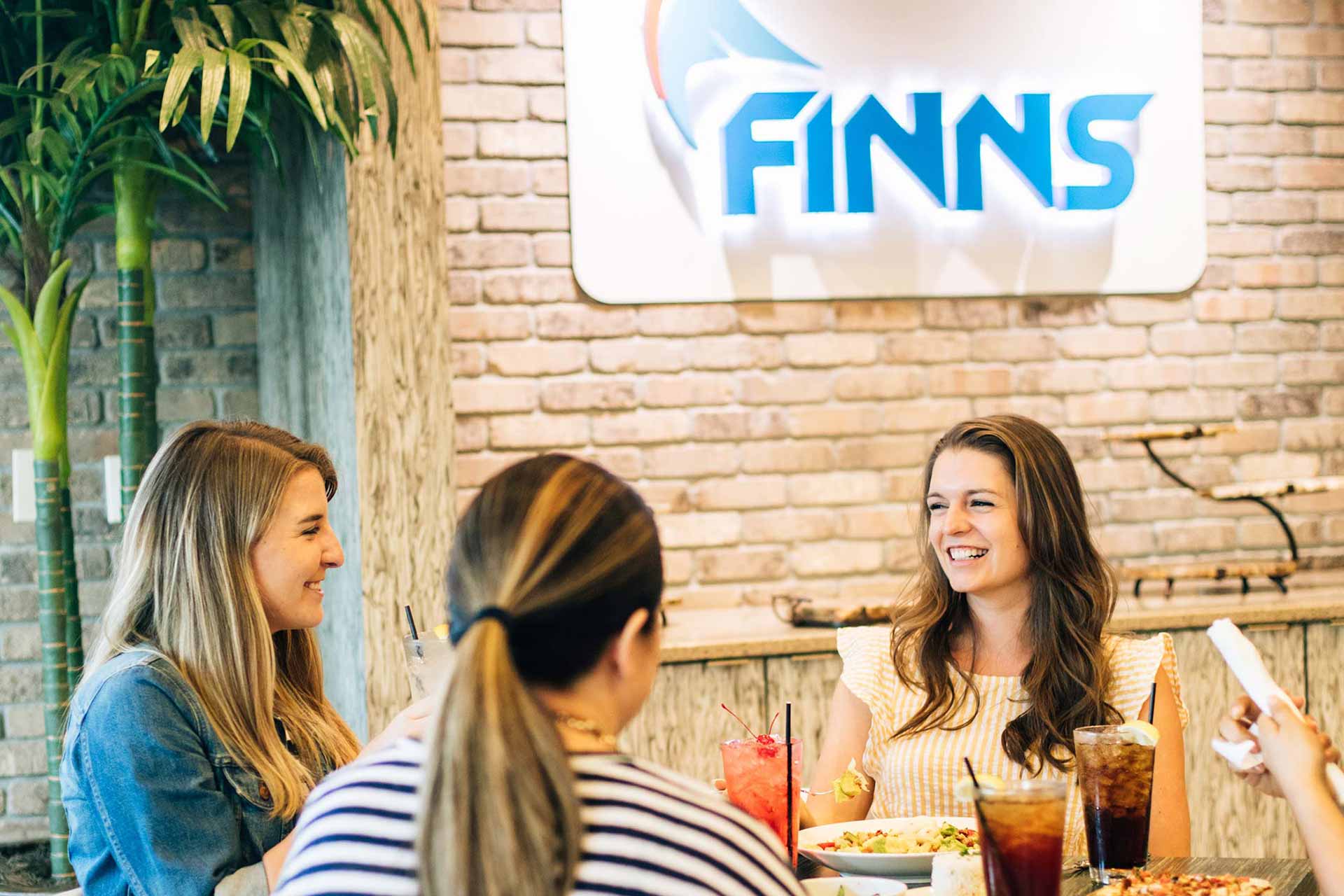 Group of friends enjoying a meal at Finns Restaurant | Encore Resort