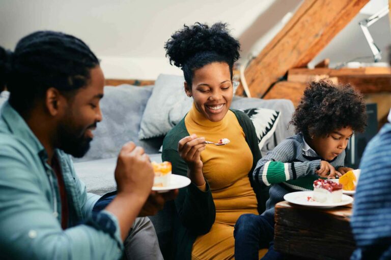 Happy family enjoying slices of cake