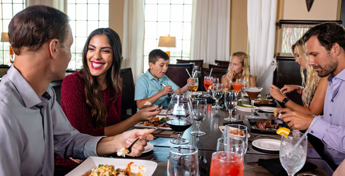 Family of parents and kids eating at Traditions restaurant in The Bear’s Den Resort Orlando’s Jack Nicklaus Clubhouse.