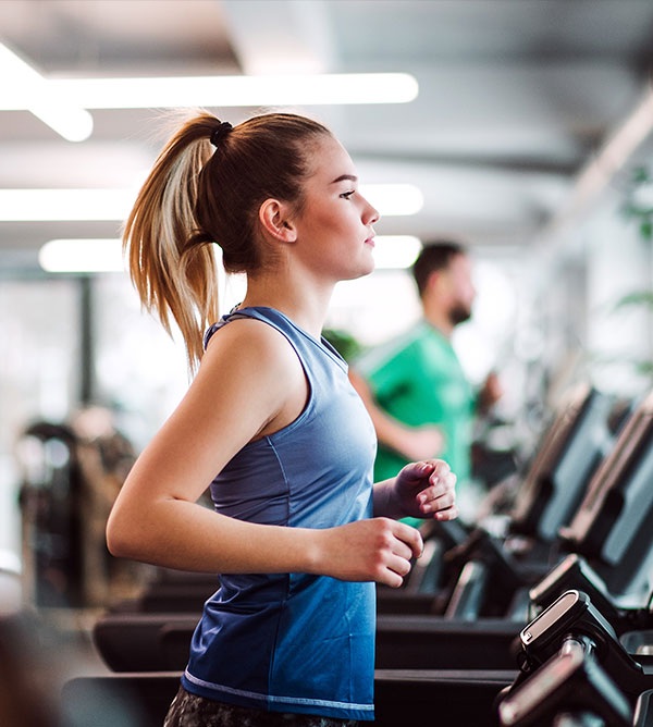 Fitness 2 Woman running on a treadmill in fitness room.