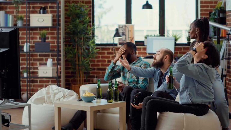 Friends angry about losing a video game while hanging out and drinking beer
