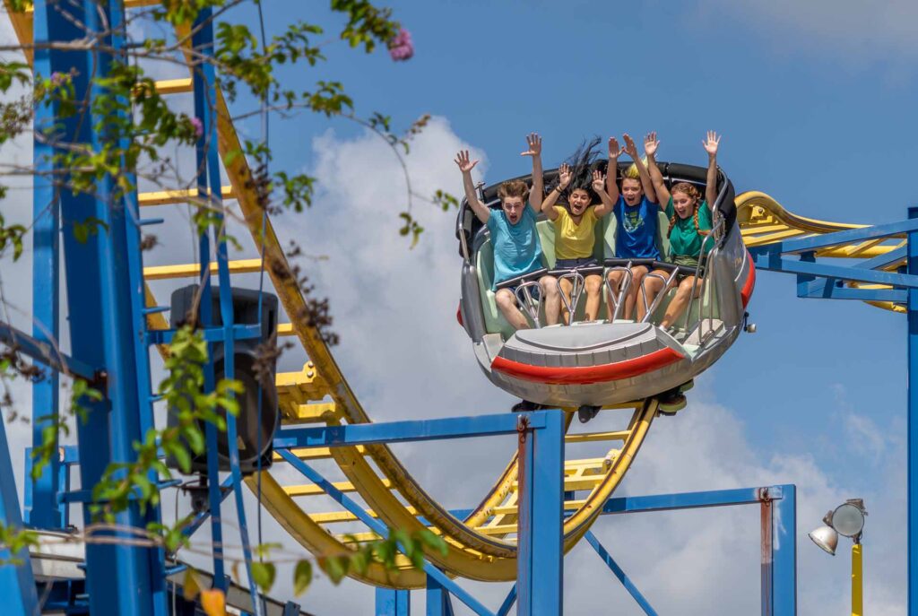 Group of friends riding on the Galaxy Spin roller coaster in Fun Spot America in Kissimmee, Florida