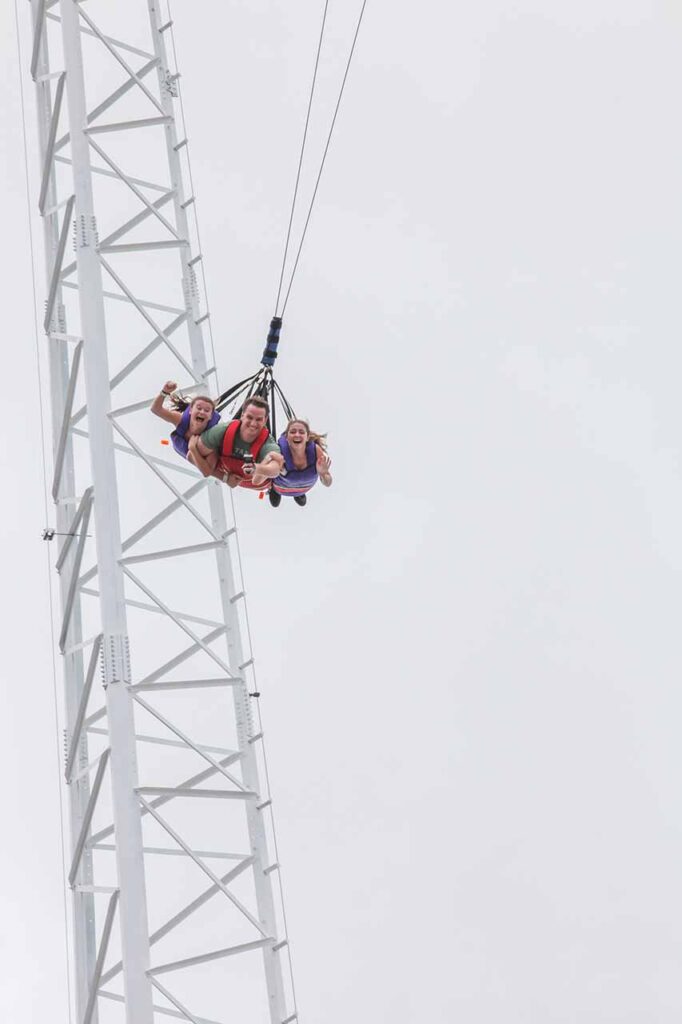 Father and daughters riding the Sky Coaster in Fun Spot America in Orlando, Florida