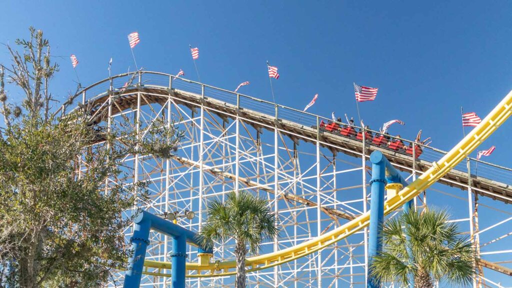 Group of people riding the White Lightning wooden roller coaster at Fun Spot America in Orlando, Florida
